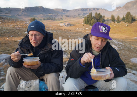 L'homme et de la femme de manger au camp en Alaska Bassin, Grand Tetons National Park, Wyoming. Banque D'Images