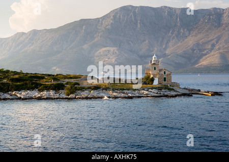 Le phare sur l'île de Hvar Croatie avec des montagnes de Biokovo derrière Banque D'Images