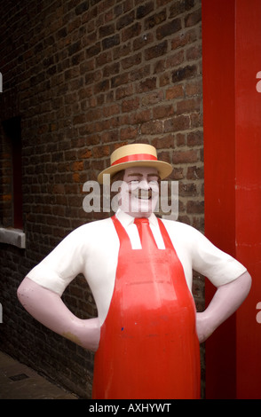 Modèle rouge Butcher contre mur de briques avec un chapeau Banque D'Images