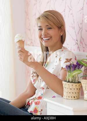 Hispanic woman eating ice cream cone Banque D'Images