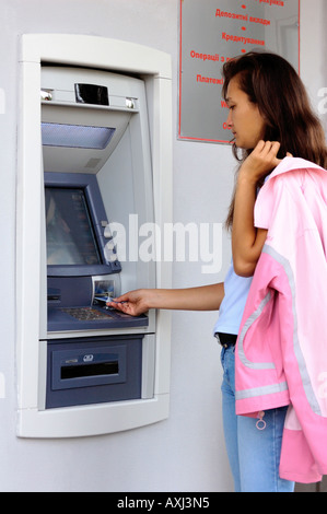 Jeune femme en utilisant un guichet automatique Banque D'Images