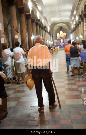 Un homme âgé s'appuyant sur l'église catholique de canne à Suchitoto El Salvador Banque D'Images