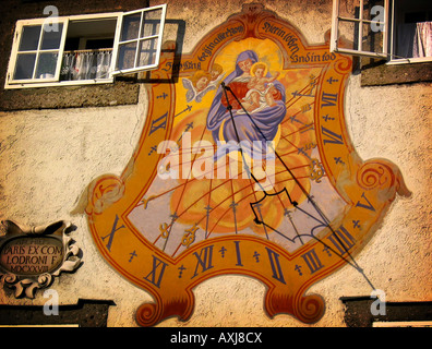 Cadran solaire sur le mur en Autriche dans la lumière du soleil avec la Vierge Marie et l'enfant Jesue. Banque D'Images