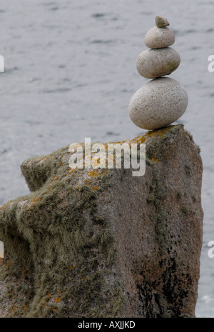 Une colonne de pierres de granit arrondis empilés sur un bloc de granite à la mer Banque D'Images