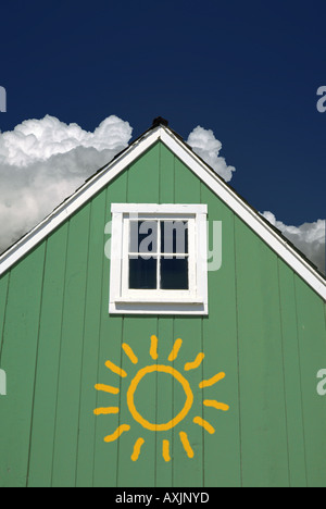 Little green house gable avec carré blanc peu de fenêtre et un peu de soleil peint sur elle Banque D'Images