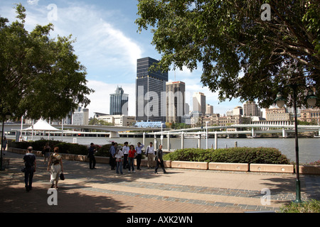 Les gens qui marchent sur la rive sud avec le quartier d'affaires central au-delà de la rivière Brisbane Queensland QLD Australie Banque D'Images