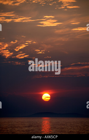 Soirée coucher de soleil avec des nuages colorés de la lumière du soleil reflétée dans la mer et les îles dans l'eau de Saronida en Attique ou Atiki Gree Banque D'Images