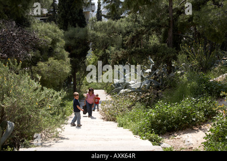 Mère et deux jeunes garçons enfants frères walking up chemin à travers les plantes vertes sur Likavitos hill ou Lycabbetus à Athènes ou à Banque D'Images