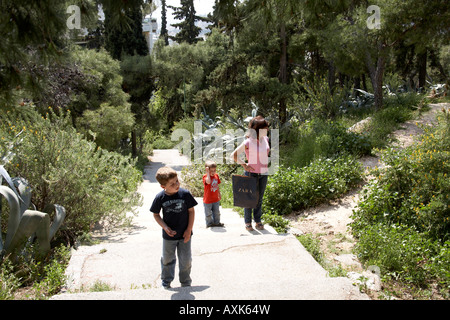 Mère et deux jeunes garçons enfants frères walking up chemin à travers les plantes vertes sur Likavitos hill ou Lycabbetus à Athènes ou à Banque D'Images