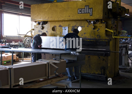 Stock photo de deux travailleurs de l'usine l'exploitation d'une machine CNC presse plieuse hydraulique Banque D'Images