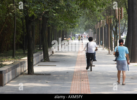 Woman and Boy à vélo le long de la chaussée piétonne, Chengdu, Chine Banque D'Images