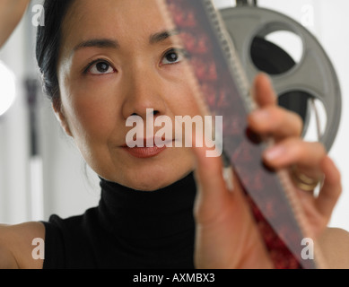 Asian woman looking at film Banque D'Images