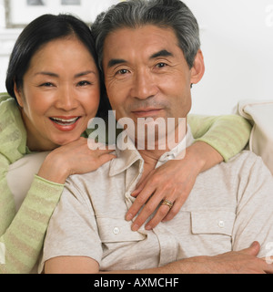 Middle aged Asian couple hugging and smiling Banque D'Images