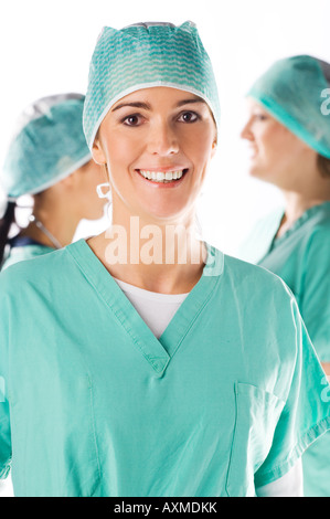 Belle jeune nurse smiling avec son équipe à l'arrière-plan Banque D'Images