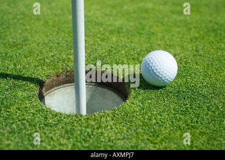 Balle de golf près de cup le putting green en plein air Banque D'Images