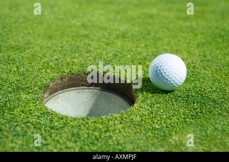 Balle de golf près de cup le putting green en plein air Banque D'Images