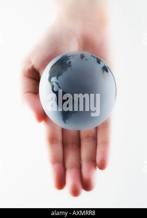 Main tenant un globe miniature