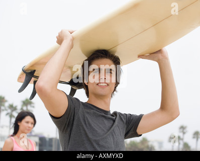 Man carrying surfboard on head Banque D'Images