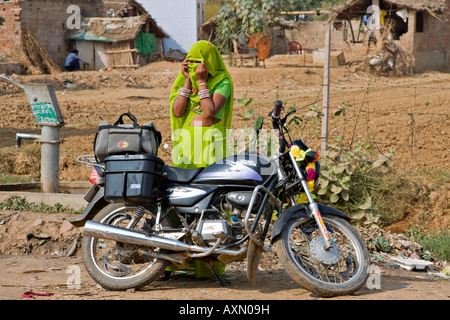 Râjasthânî femme debout à côté d'une moto couvrant son visage, Inde Banque D'Images