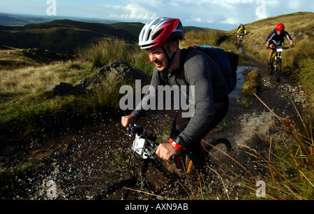 Mountain bike rider sur le sentier de l'eau éclaboussant par Banque D'Images