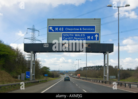 Vue horizontale de voitures roulant sous une autoroute bras signe avec la matrice des feux de détresse à ralentir. Banque D'Images