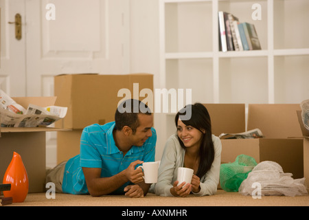 Jeune couple à côté de boîtes de déménagement déballé Banque D'Images