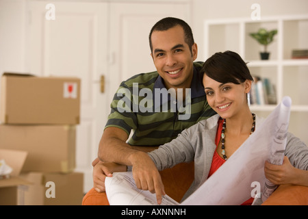 Jeune couple looking at blueprints in new house Banque D'Images