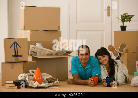 Jeune couple à côté de boîtes de déménagement déballé Banque D'Images