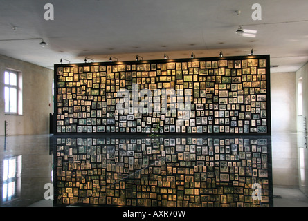 Panel de photographies de famille dans le sauna, à l'l'ancien camp de concentration Nazi, Auschwitz-Birkenau, en Pologne. Banque D'Images