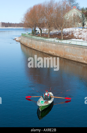 Pêcheur qui traîne d'un barque / skiff à la rivière Oulujoki , Finlande Banque D'Images