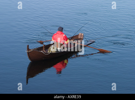 Pêche à l'aviron et au trolling en utilisant une barque traditionnelle en bois / skiff à la rivière Oulujoki , Finlande Banque D'Images