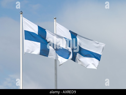 Deux drapeaux finlandais volant dans le vent contre le ciel bleu et blanc , Finlande Banque D'Images