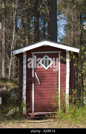 À l'ancienne, en bois rouge outhouse dans la forêt , Finlande Banque D'Images