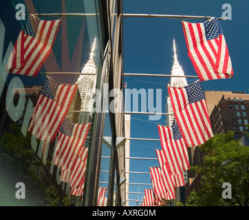 Une rangée de drapeaux américains reflètent dans une fenêtre, avec le Chrysler Building à l'arrière-plan. Midtown Manhattan New York USA Banque D'Images