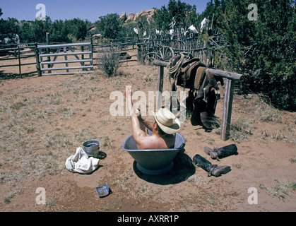 Un cowboy et historien Marc Simmons prend un bain dans une baignoire en métal sur son petit ranch dans le bassin Galisteo Banque D'Images