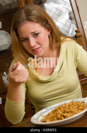 Réticents Caucasian Girl 15 à 17 mange des aliments amers USA Banque D'Images