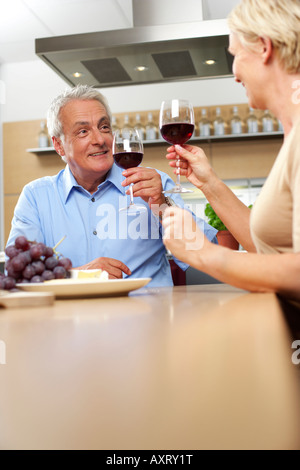 Homme aux cheveux gris et blond woman clinking glasses, low angle view Banque D'Images