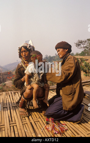 L'homme de médecine applique le cataplasme naturel au visage des enfants. Akha village Pala dans les montagnes du nord de la Thaïlande. HOMER SYKES des années 1990 Banque D'Images