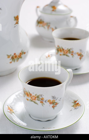 Café (ou thé) situé sur la table - tasse de café à l'avant (l'accent sur elle) de sucre derrière le bassin. Profondeur de champ. Banque D'Images