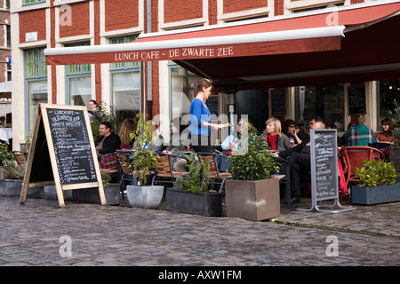 Les clients de manger dehors à la terrasse d'un café restaurant à Gand, Belgique Banque D'Images