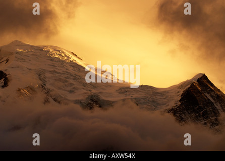 Derniers rayons de soleil avec des nuages de tempête de neige dans plus de fermeture Dôme du Goûter (4304m) et l'Aiguille du Goûter (3863m) Banque D'Images