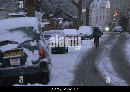 Sans feux cycliste en soirée le trafic après hiver neige Bristol UK. Banque D'Images
