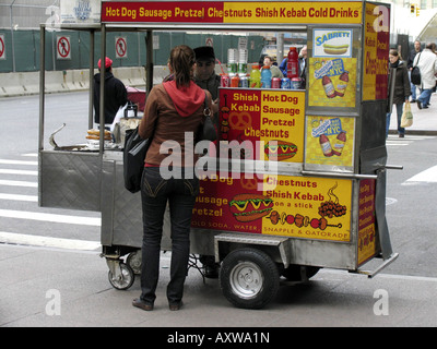 Jeune femme est l'achat d'un hot-dog, USA, Manhattan, New York Banque D'Images