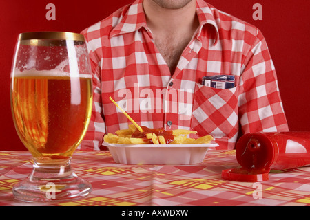 L'homme avec des frites, du ketchup et du verre de bière Banque D'Images