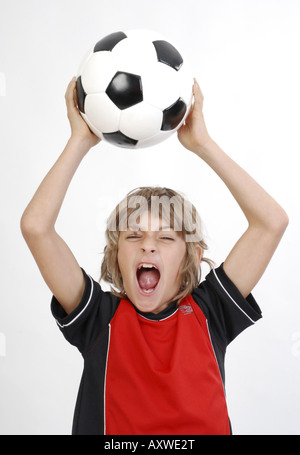 Garçon crier avec un ballon de football Banque D'Images