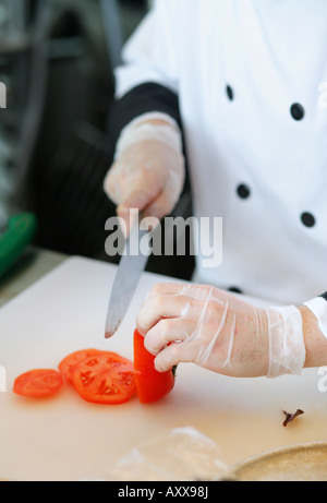 Chef de trancher une tomate Banque D'Images