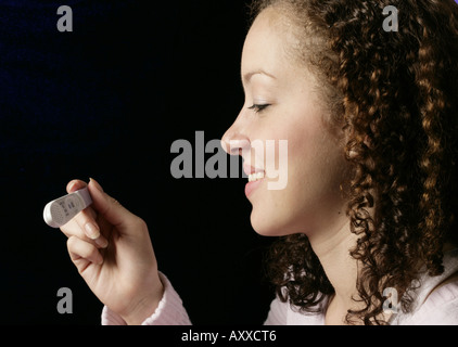 Femme sourire alors qu'elle a lu les résultats de son test de grossesse. Banque D'Images