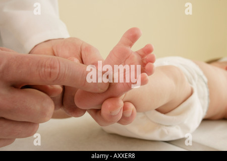 Médecin vérifie le réflexe de bébé. Banque D'Images