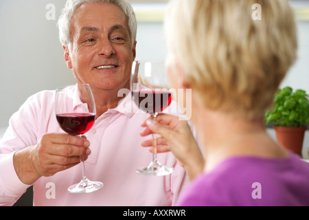 Homme aux cheveux gris et blond woman clinking glasses, low angle view Banque D'Images