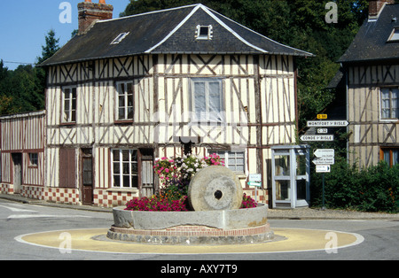 Saint Christophe sur Condé - Normandie - France ancienne meule en pierre en face d'une typique maison normande à colombages - colombage Banque D'Images